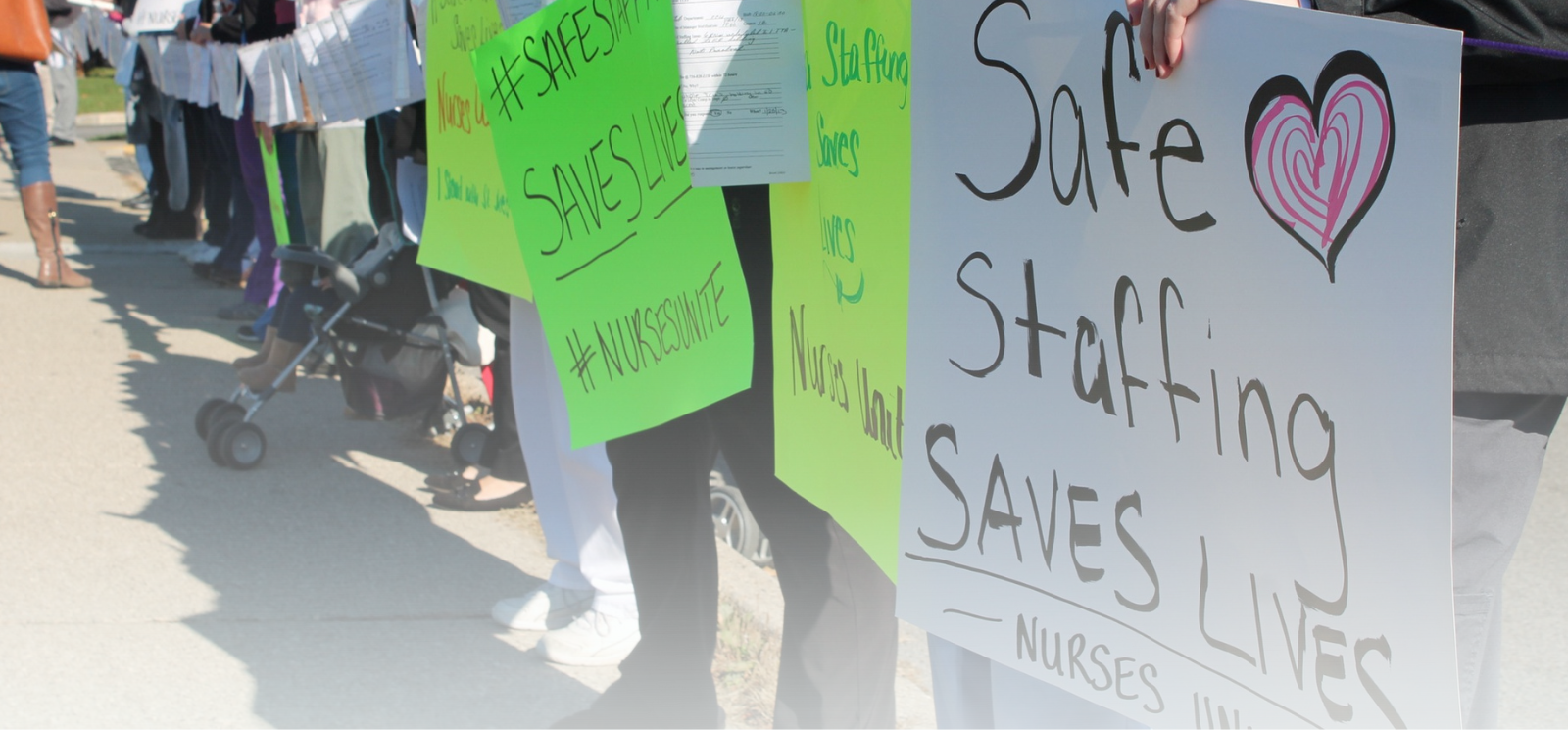 CWA members hold signs saying "Safe Staffing Saves Lives"