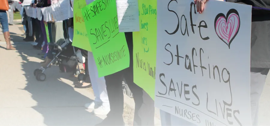 CWA members hold signs saying "Safe Staffing Saves Lives"